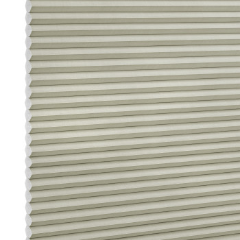 Beige honeycomb (cellular) blind with horizontal pleats and visible hexagonal cell ends at left, fully lowered and closed, blocking light; close-up filling the frame against a neutral, studio-lit background.