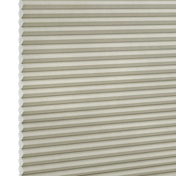 Beige honeycomb (cellular) blind with horizontal pleats and visible hexagonal cell ends at left, fully lowered and closed, blocking light; close-up filling the frame against a neutral, studio-lit background.