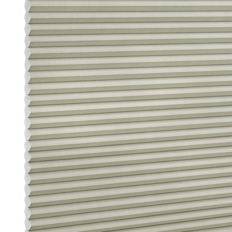 Beige honeycomb (cellular) blind with horizontal pleats and visible hexagonal cell ends at left, fully lowered and closed, blocking light; close-up filling the frame against a neutral, studio-lit background.