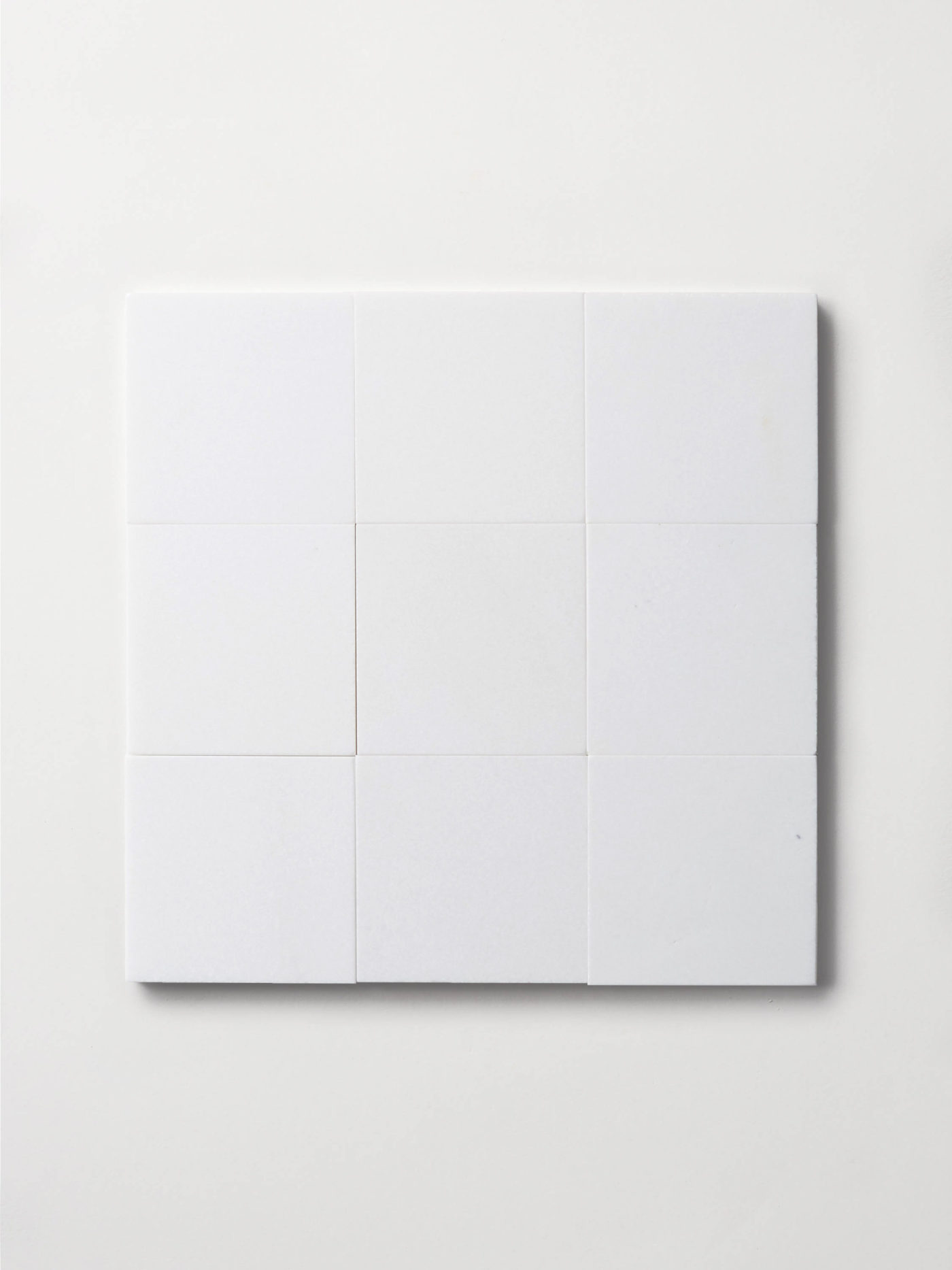 a set of white square tiles on a white surface.