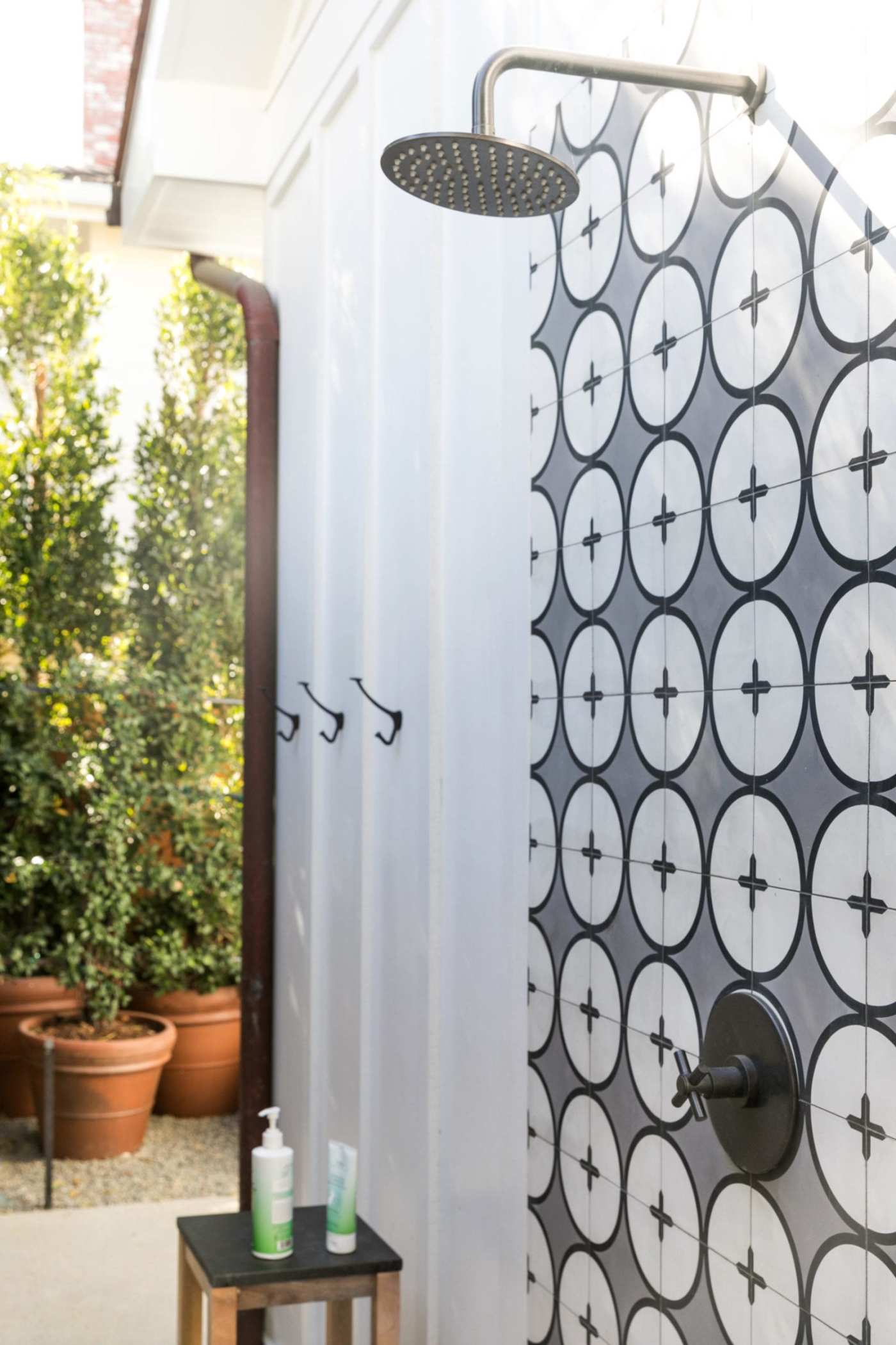 a black and white tiled shower in a backyard.