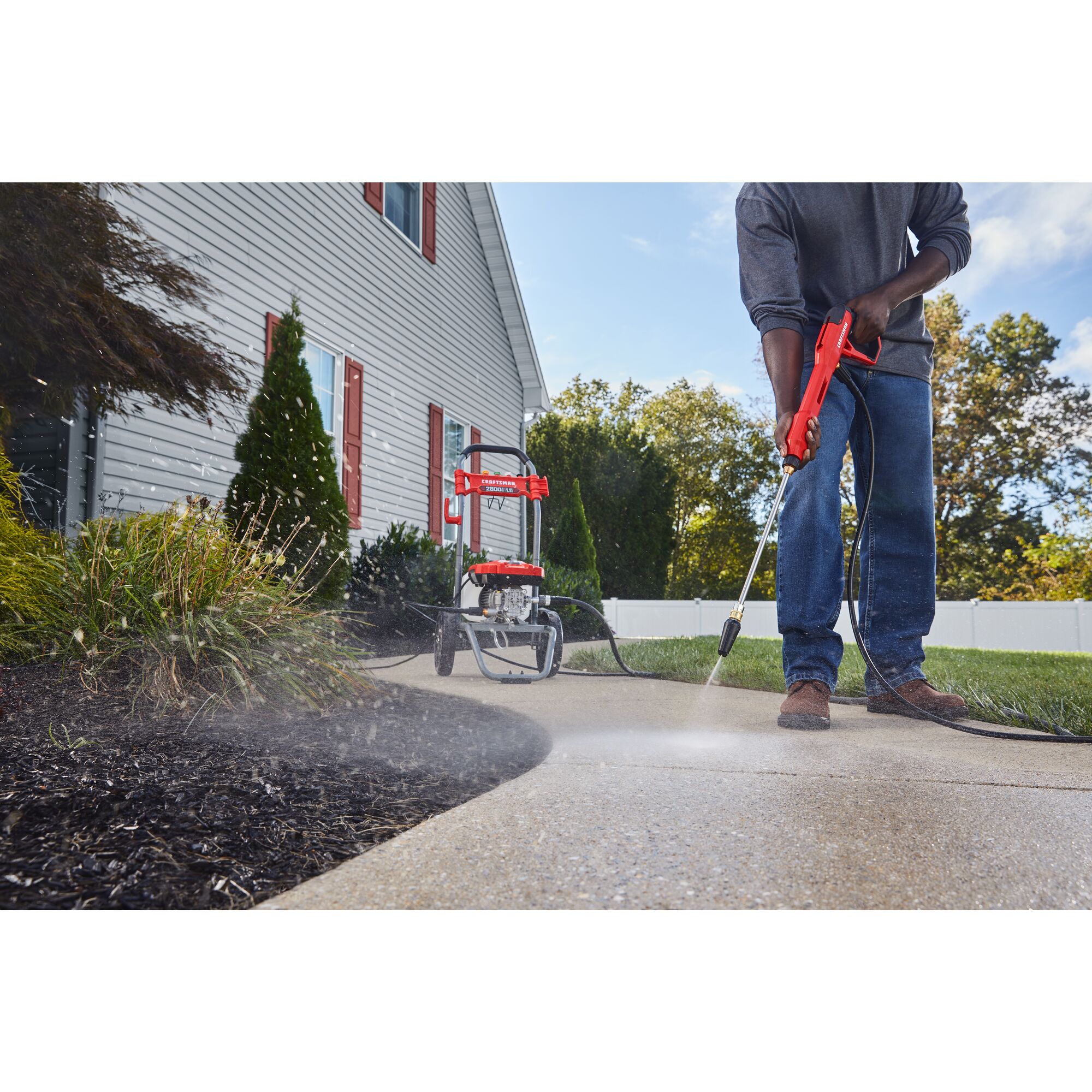 CRAFTSMAN 2800 Pressure Washer pressure washing sidewalk with flowerbed in background