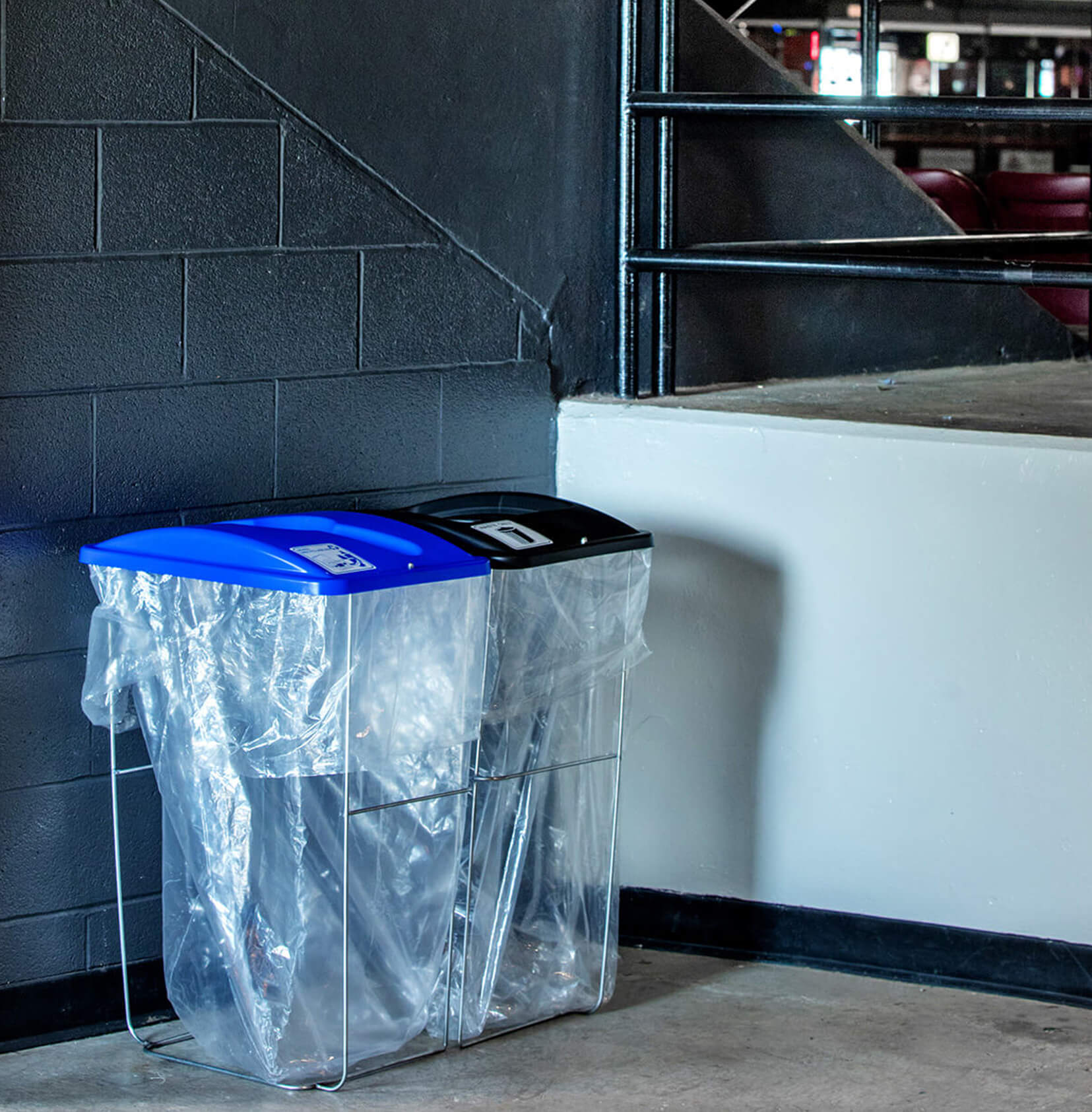 event containers with color coded lids with labels for collection trash and recyclables at a sports stadium