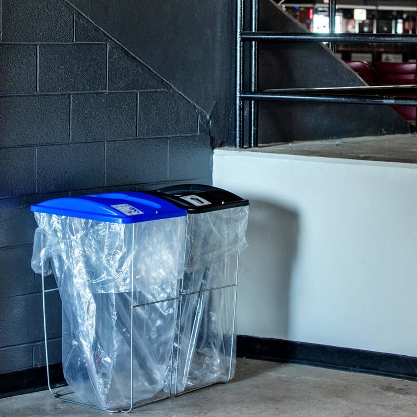event containers with color coded lids with labels for collection trash and recyclables at a sports stadium