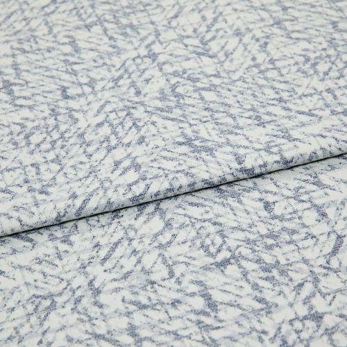 Light blue-and-white patterned fabric folded once, overlapping; textured woven surface with irregular, fern-like striations, photographed close-up under even studio lighting.