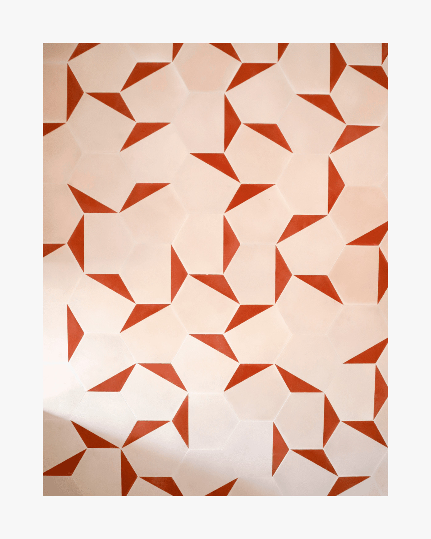 a tiled wall with a pink and red geometric pattern.
