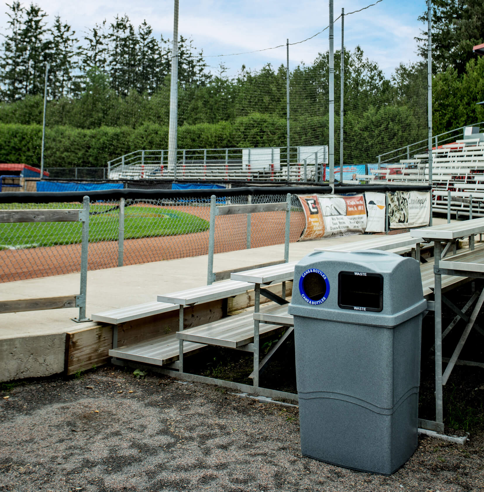 double grey waste and recycling bin with canopy lid outside at a baseball field