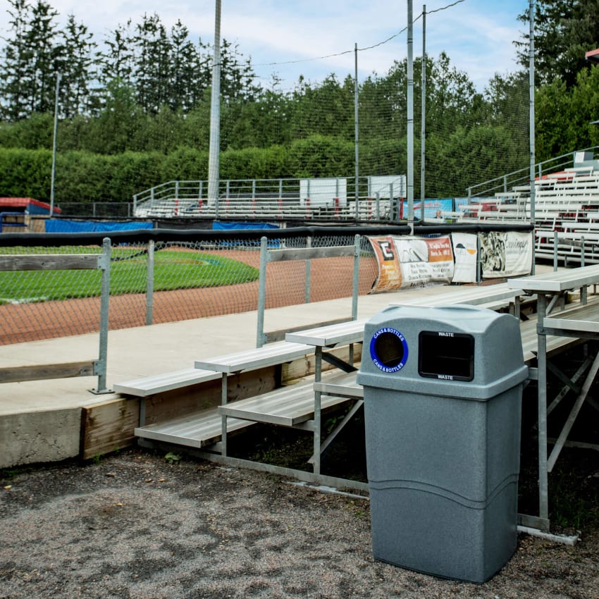 double grey waste and recycling bin with canopy lid outside at a baseball field