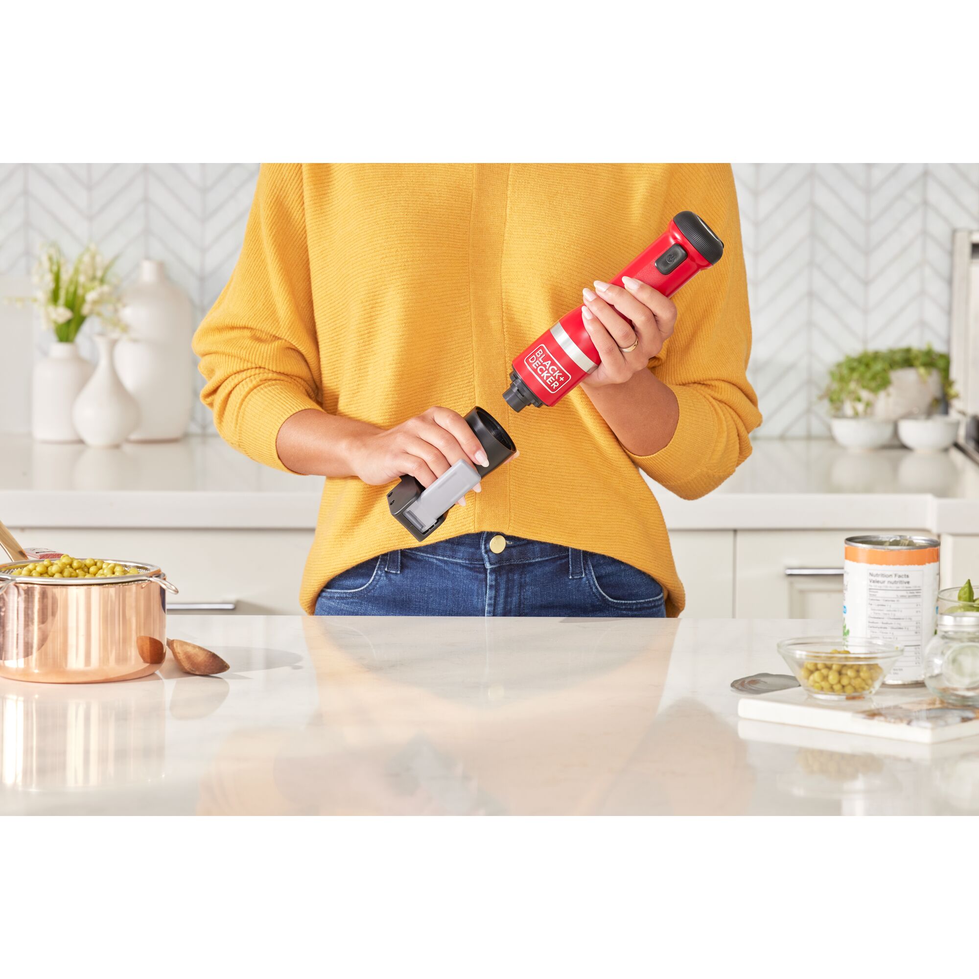 Talent showing how to attach the BLACK+DECKER kitchen wand can opener attachment to the red power unit