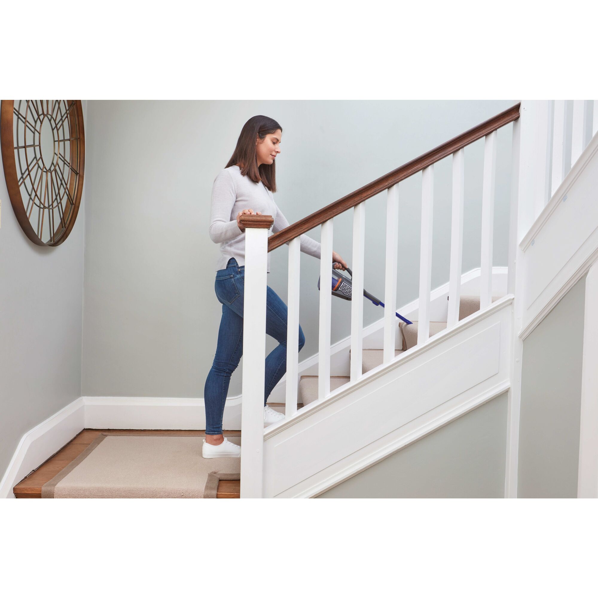 dustbuster AdvancedClean pet cordless hand vacuum being used by a person to clean stairs.