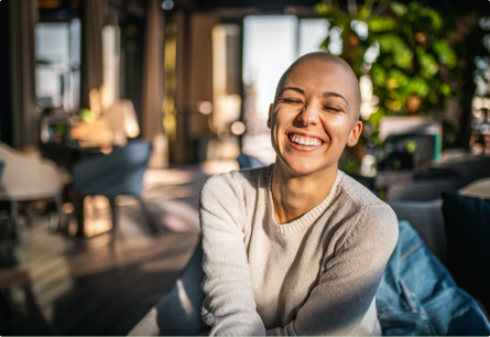 Premium Source A woman in a sweater smiling with her eyes closed.
