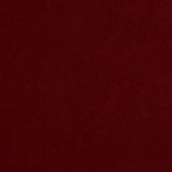 Solid burgundy fabric fills the frame, lying flat with subtle texture; evenly lit, featureless surface suggests a plain backdrop or sheet in low, diffuse light.