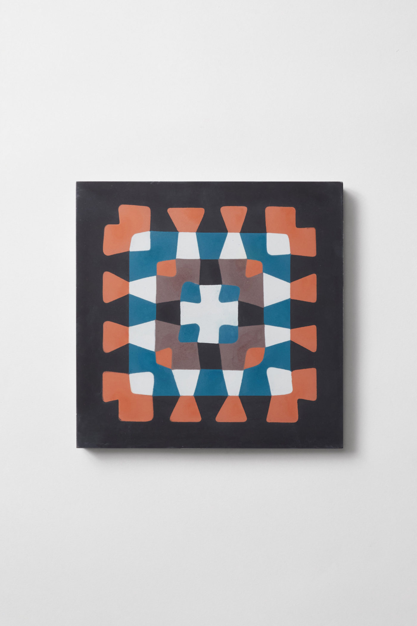 a tile with a blue, orange and black abstract crochet design.