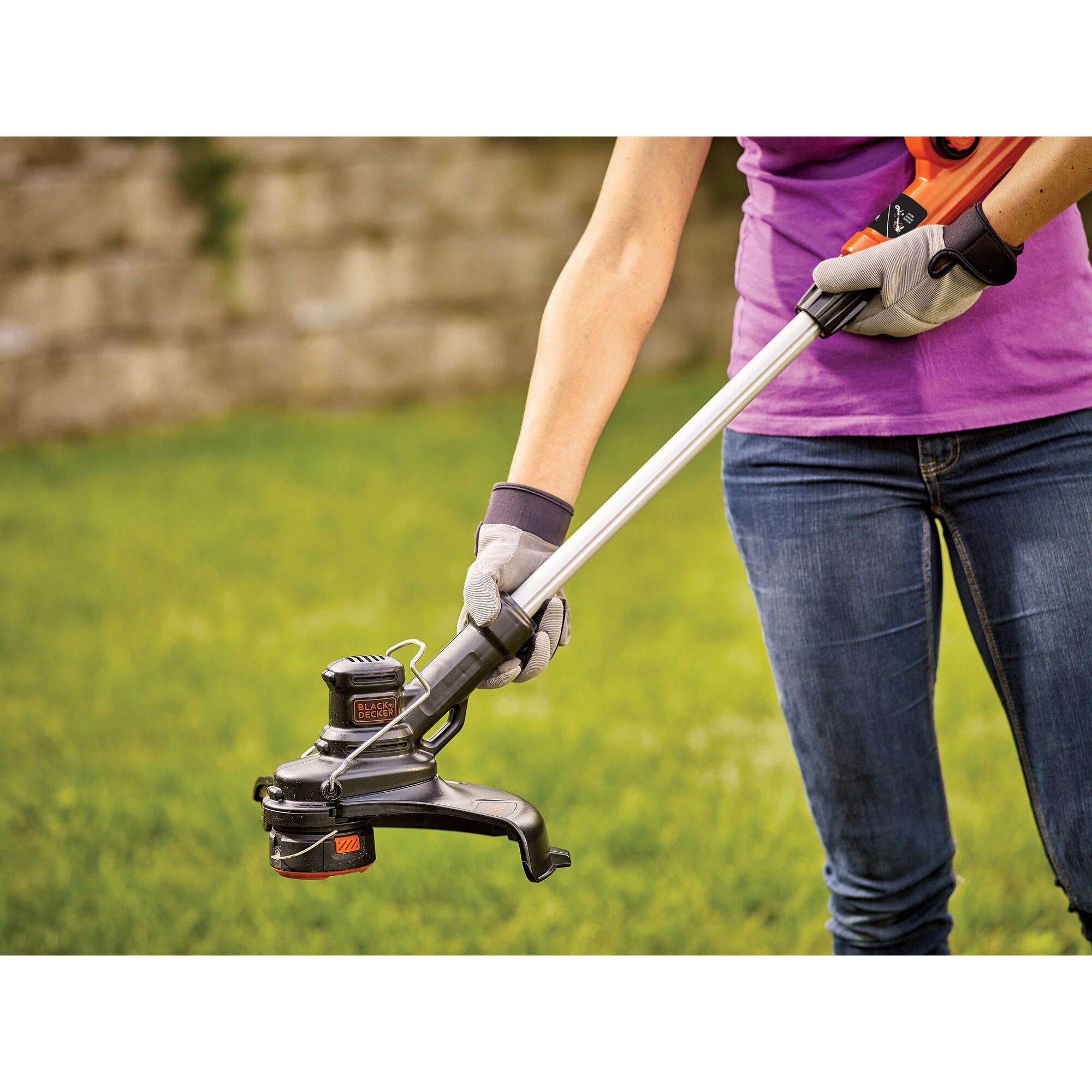 Woman extending the 40V MAX* Cordless String Trimmer pole.