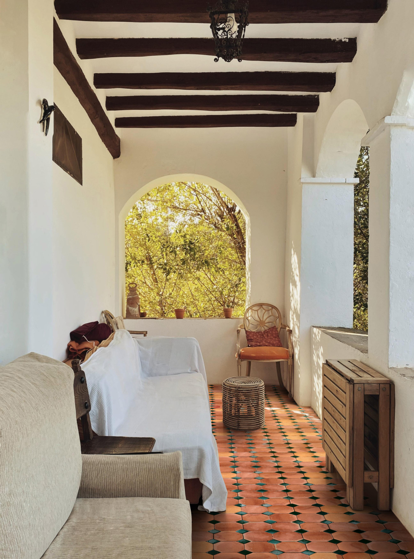 a tiled porch with a table and chairs.