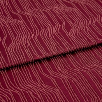 Burgundy fabric with raised, irregular pale-pink wavy lines (textured pile), folded once across the center, lying flat in a close-up, evenly lit studio view, showing pattern and subtle shadows.