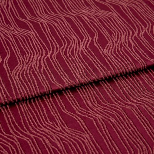 Burgundy fabric with raised, irregular pale-pink wavy lines (textured pile), folded once across the center, lying flat in a close-up, evenly lit studio view, showing pattern and subtle shadows.