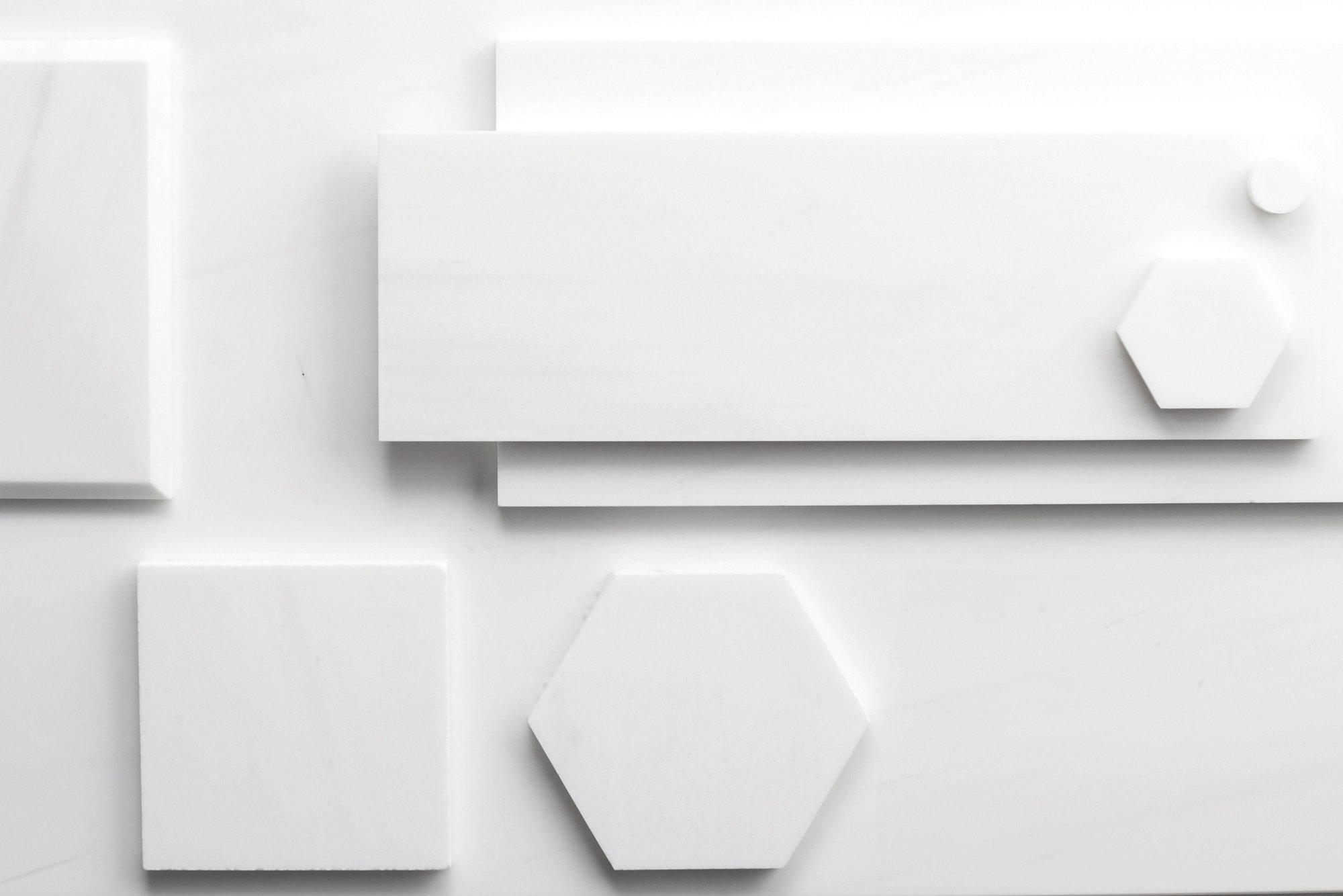 various shapes and sizes of white tiles on a white surface.