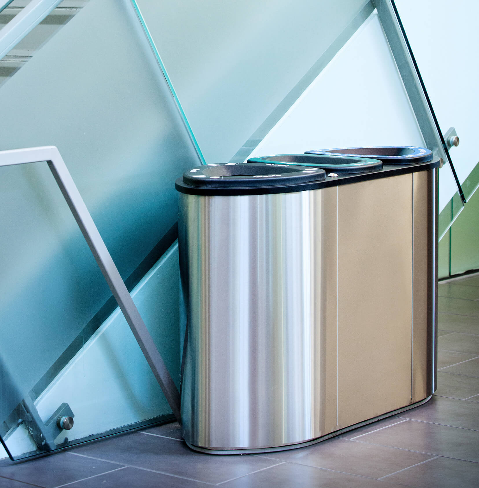 stainless steel waste and recycling container in a modern office building