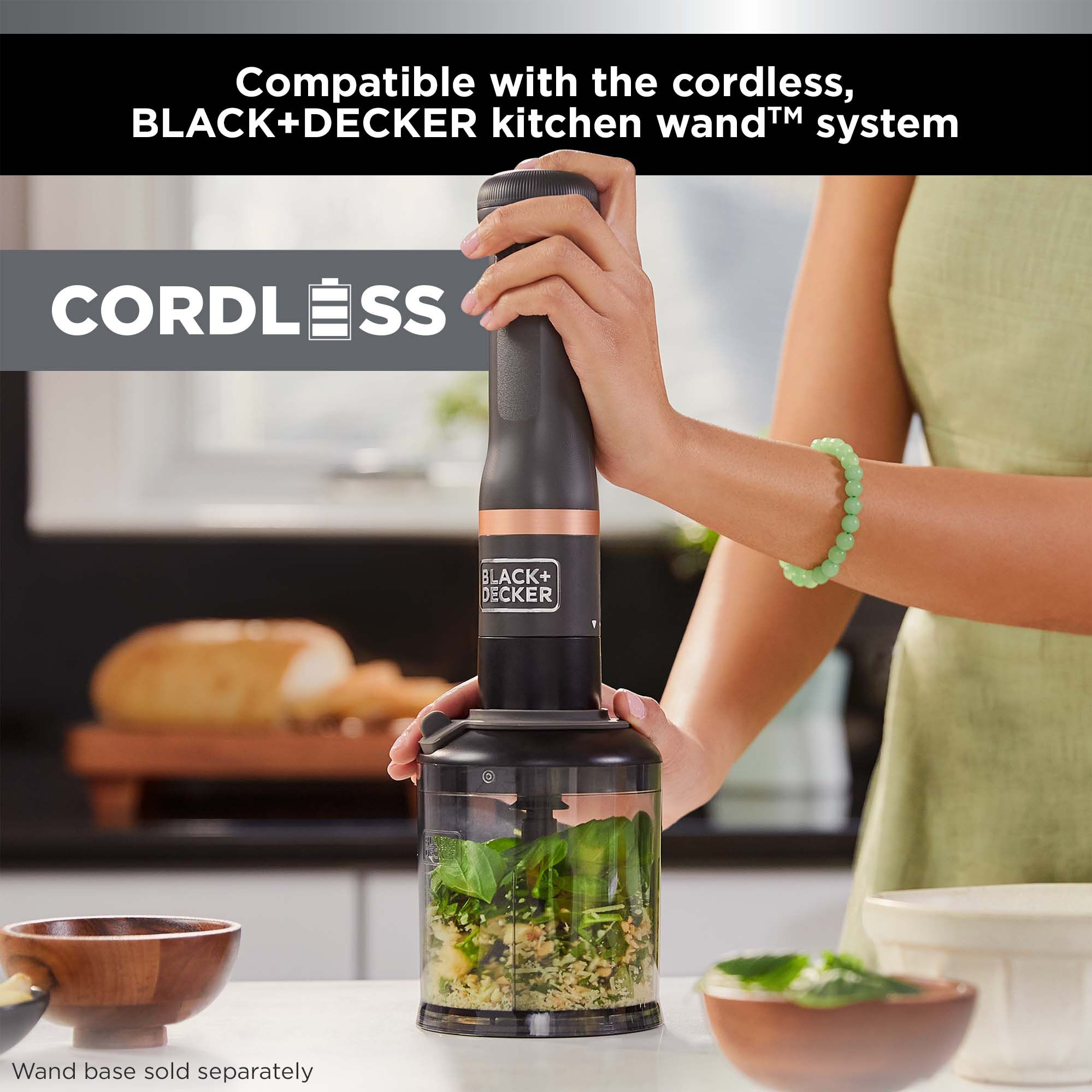 Talent using the BLACK+DECKER kitchen wand™ food chopper attachment  with the grey wand base to show it is cordless