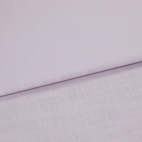 Pale lavender linen fabric folded across the frame, edge running diagonally; resting in soft layers, close-up on fine woven texture under diffuse lighting.