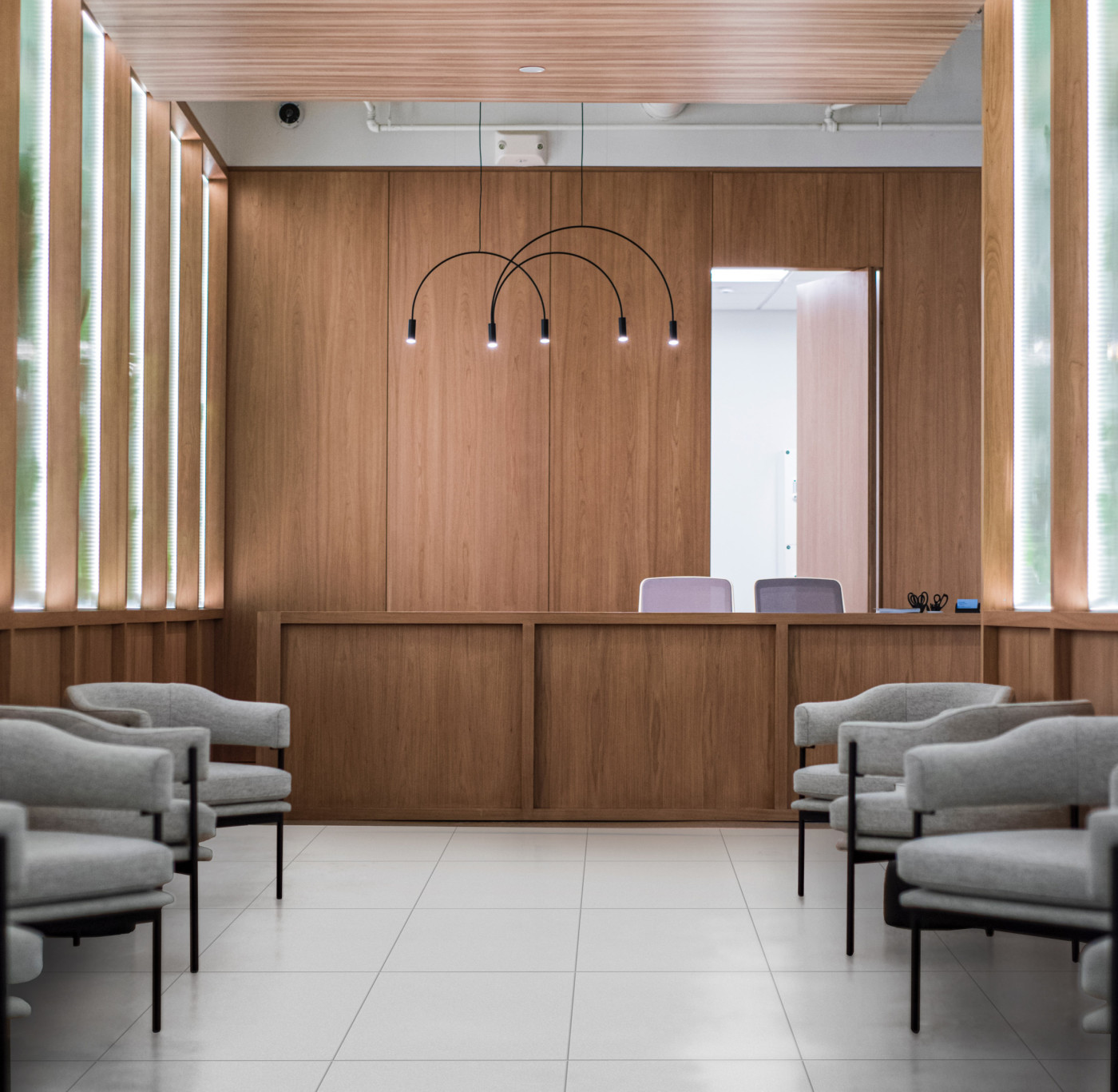 a waiting room with chairs and a large wooden desk.