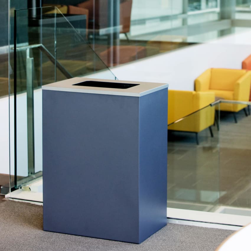 large capacity powder coated steel waste container in a college campus