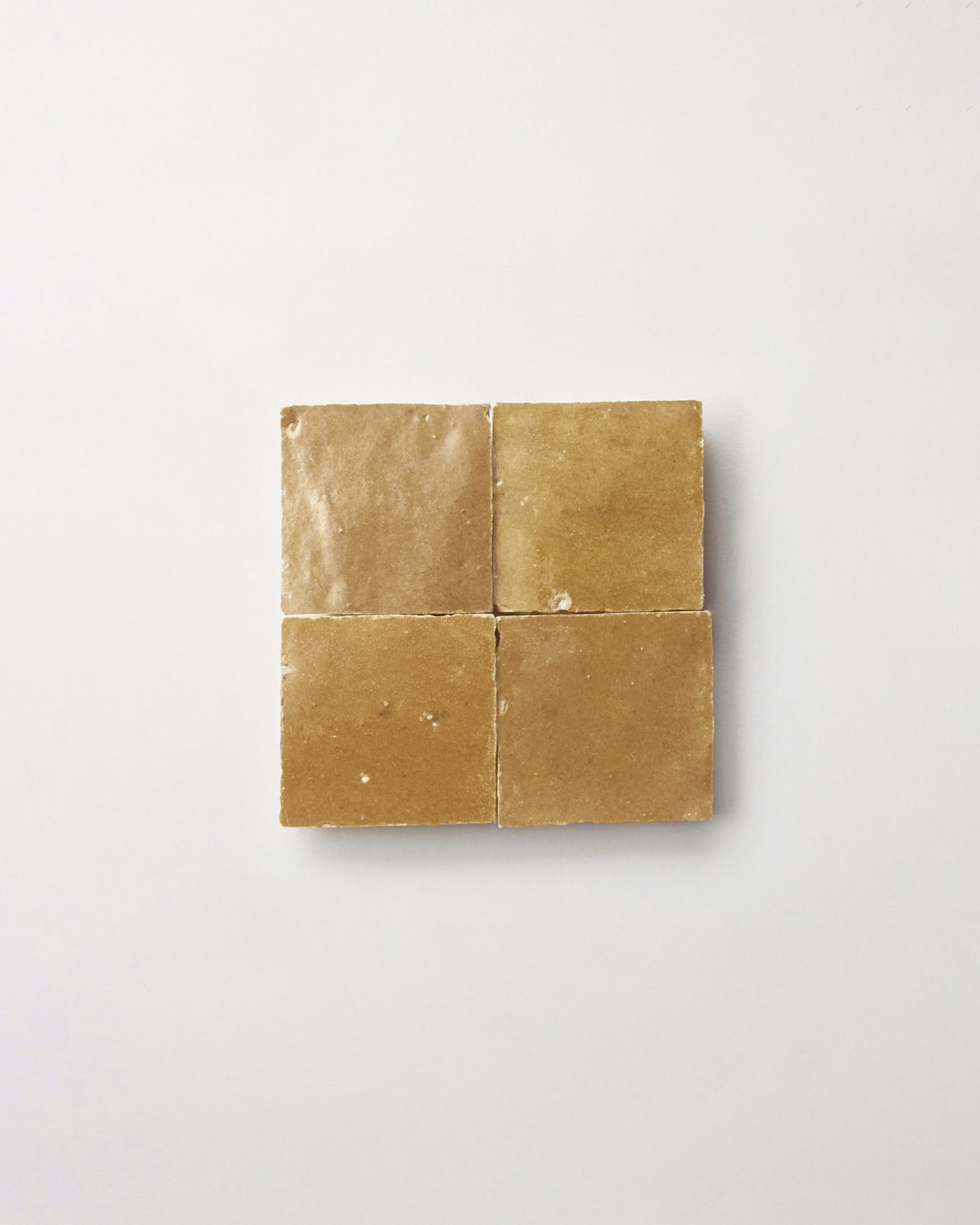 4 squares of brown tile on a white surface.