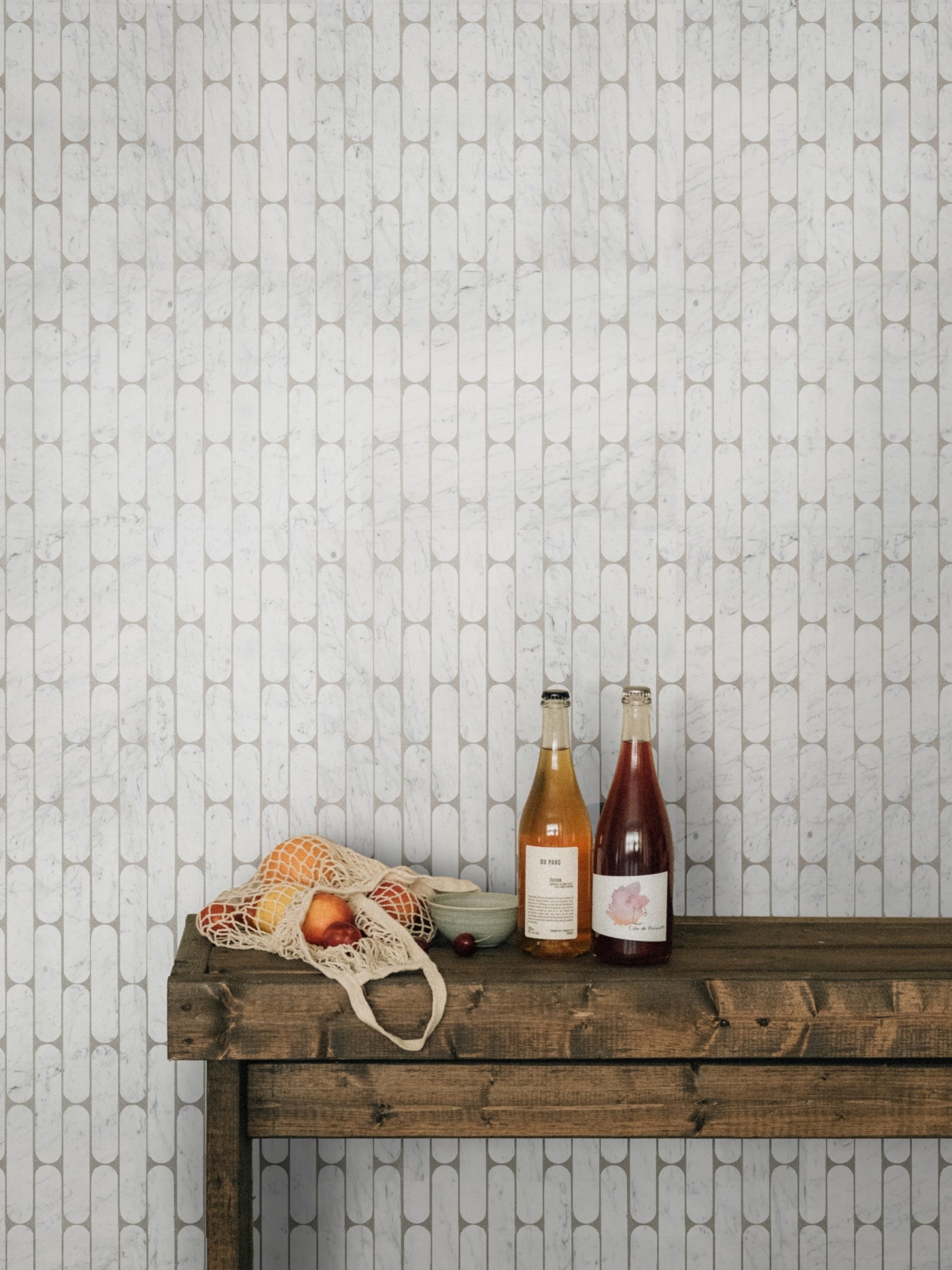 a wooden table with 2 bottles on it in front of a white tiled wall.