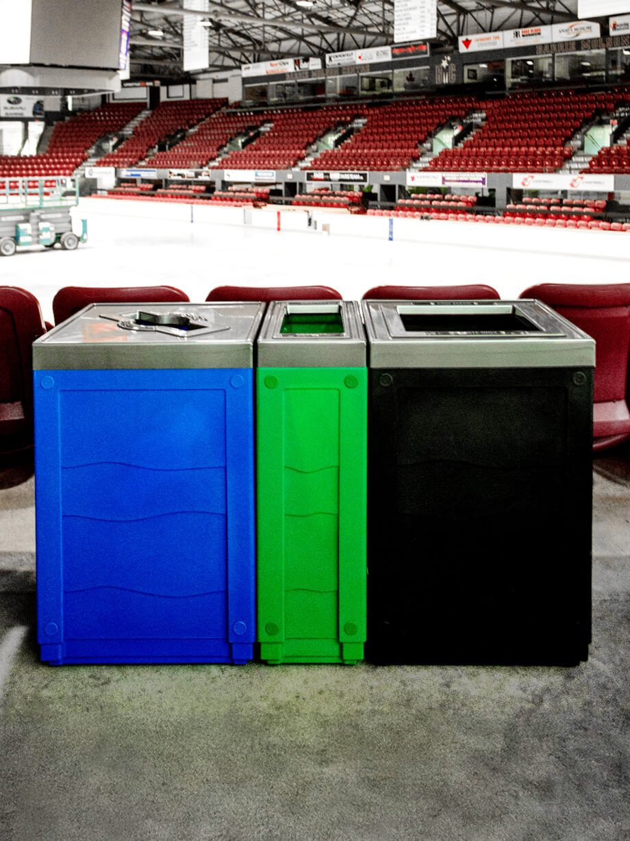 triple color-coded waste organics and recycling bins in a hockey arena placed behind the seats