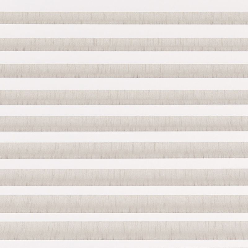 Striped zebra roller blind, full-width with alternating beige textured and white translucent horizontal bands, lowered and aligned, filtering diffuse daylight in a neutral-toned interior without any visible outside view.