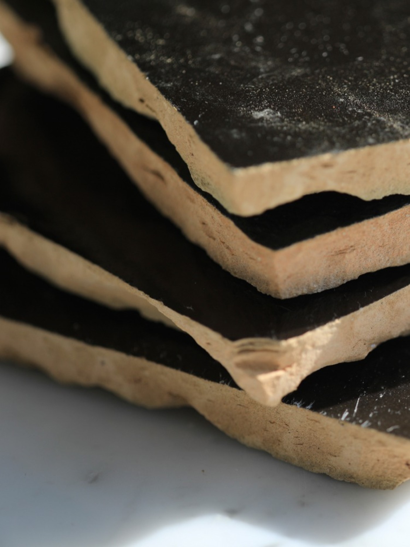 a stack of black tiles on a marble table.