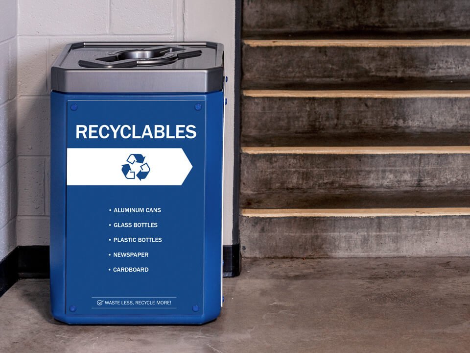 single stream recycling container with its body made from 100% post-consumer recycled material showing a full body sign and brushed pewter mixed opening lid at a hockey arena