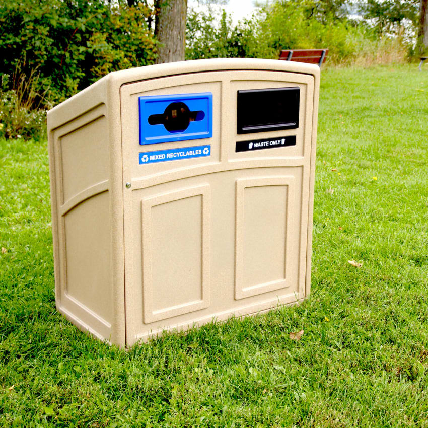 beige plastic double opening waste and recycling bin with sloped lid and color openings in a picnic area along the waterfront