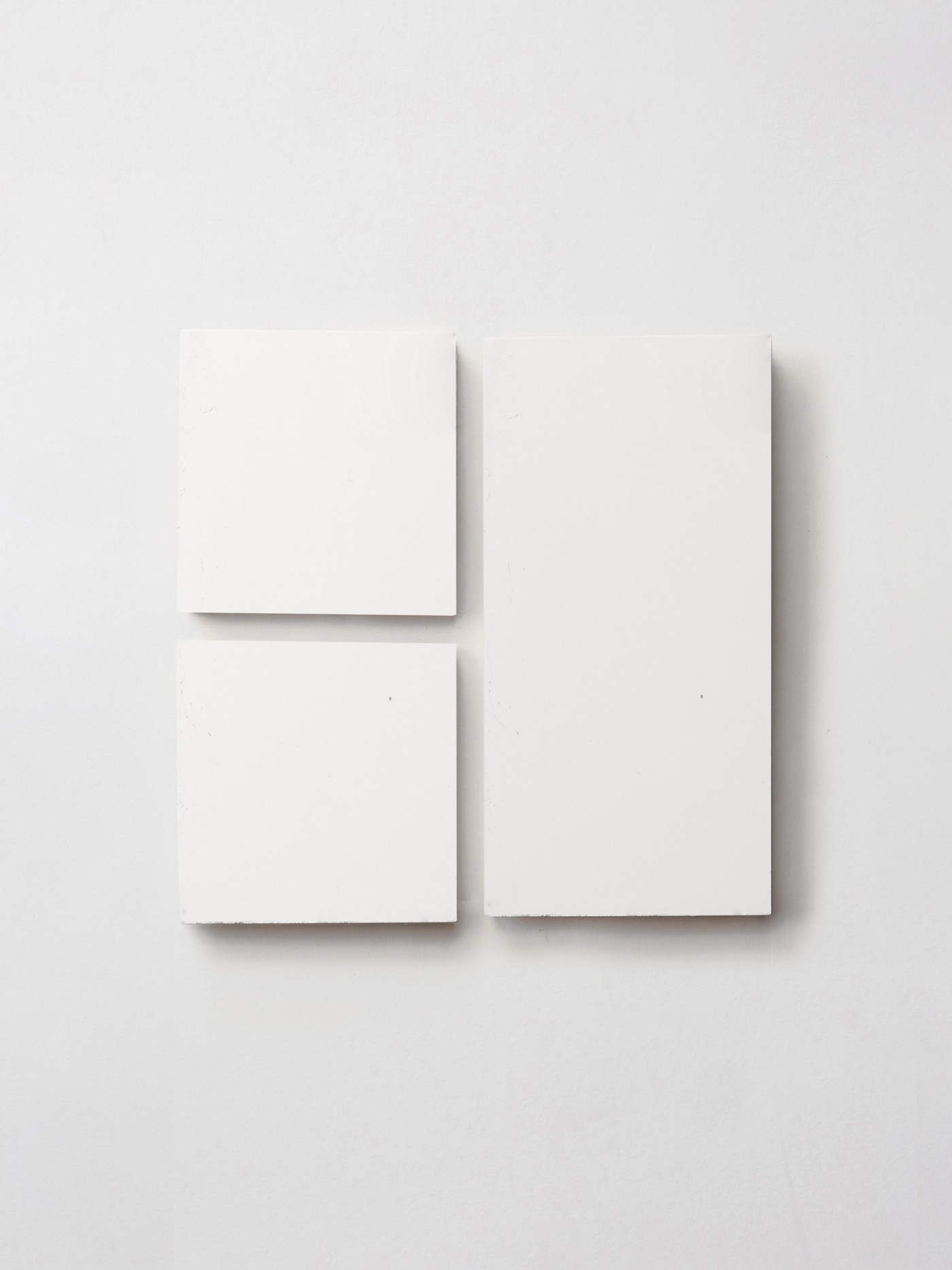 three white tiles on a white surface.