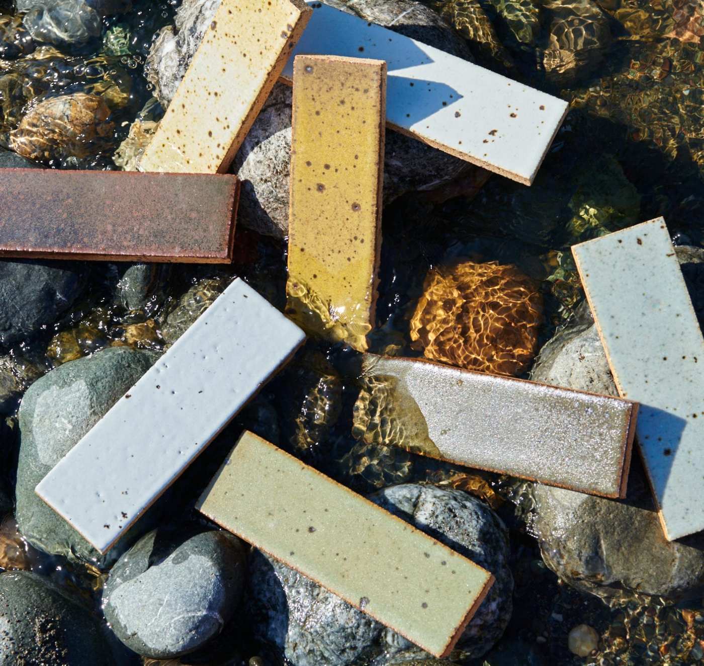 a group of tiles laying on rocks in the water.