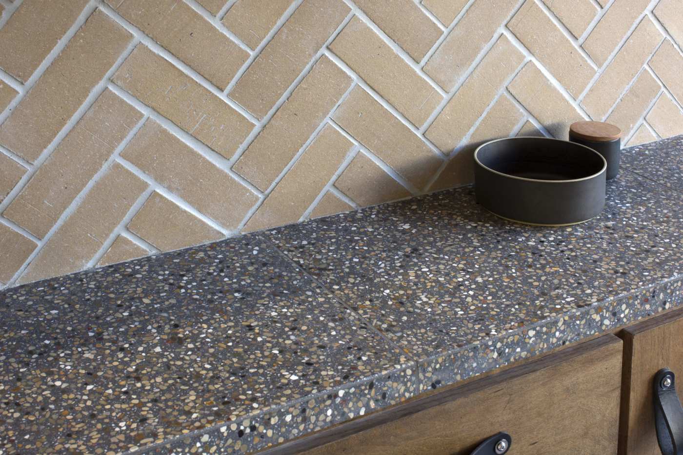 a grey terrazzo tiled kitchen counter with a bowl on it.