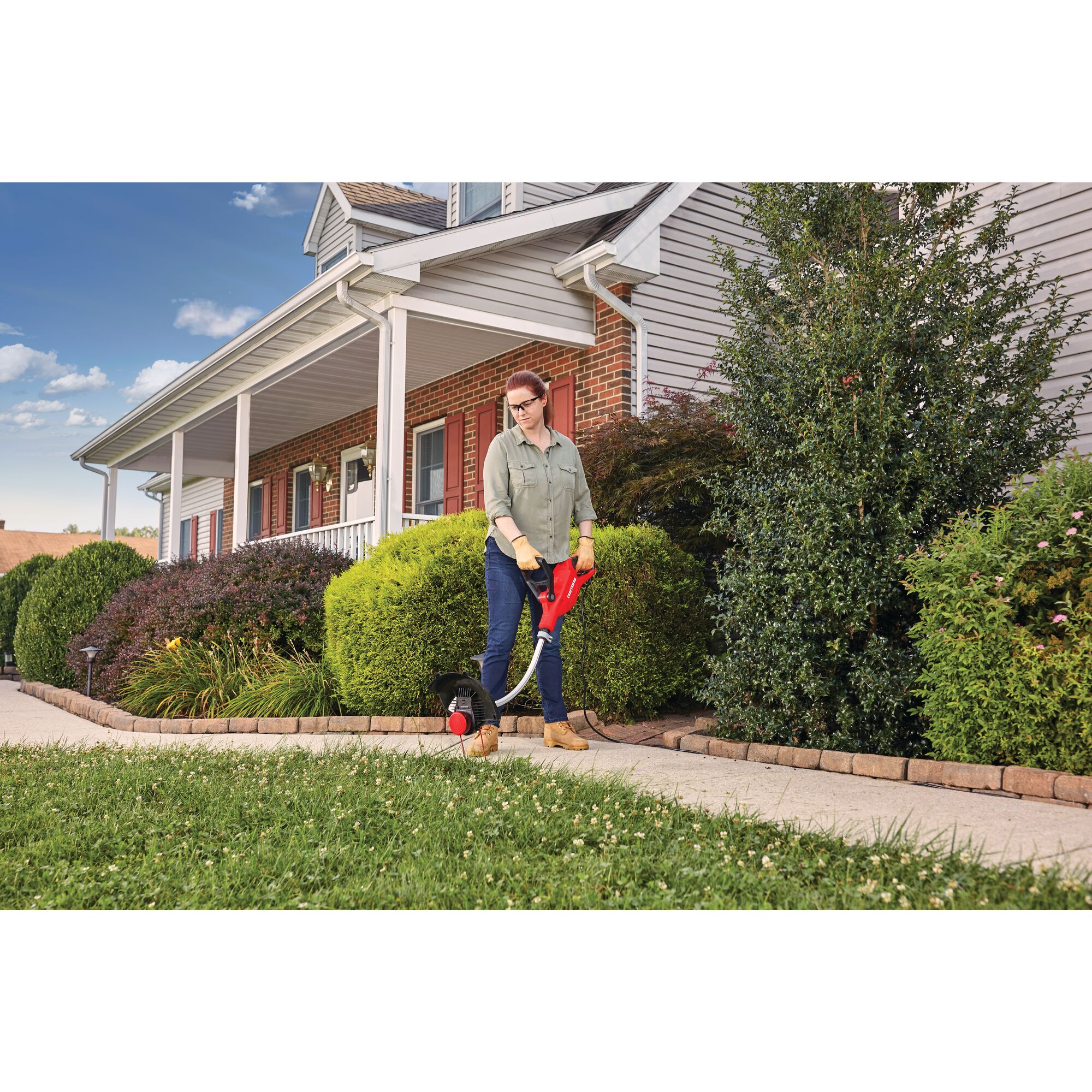 Weedwacker 8.5 amp 14 inch corded electric string trimmer being used by a person to trim grass.