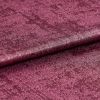 Crushed velvet fabric swatch, folded across the frame with a subtle roll, shimmering and reflecting light; deep magenta color, close-up studio shot emphasizing soft, textured pile.