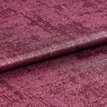 Crushed velvet fabric swatch, folded across the frame with a subtle roll, shimmering and reflecting light; deep magenta color, close-up studio shot emphasizing soft, textured pile.
