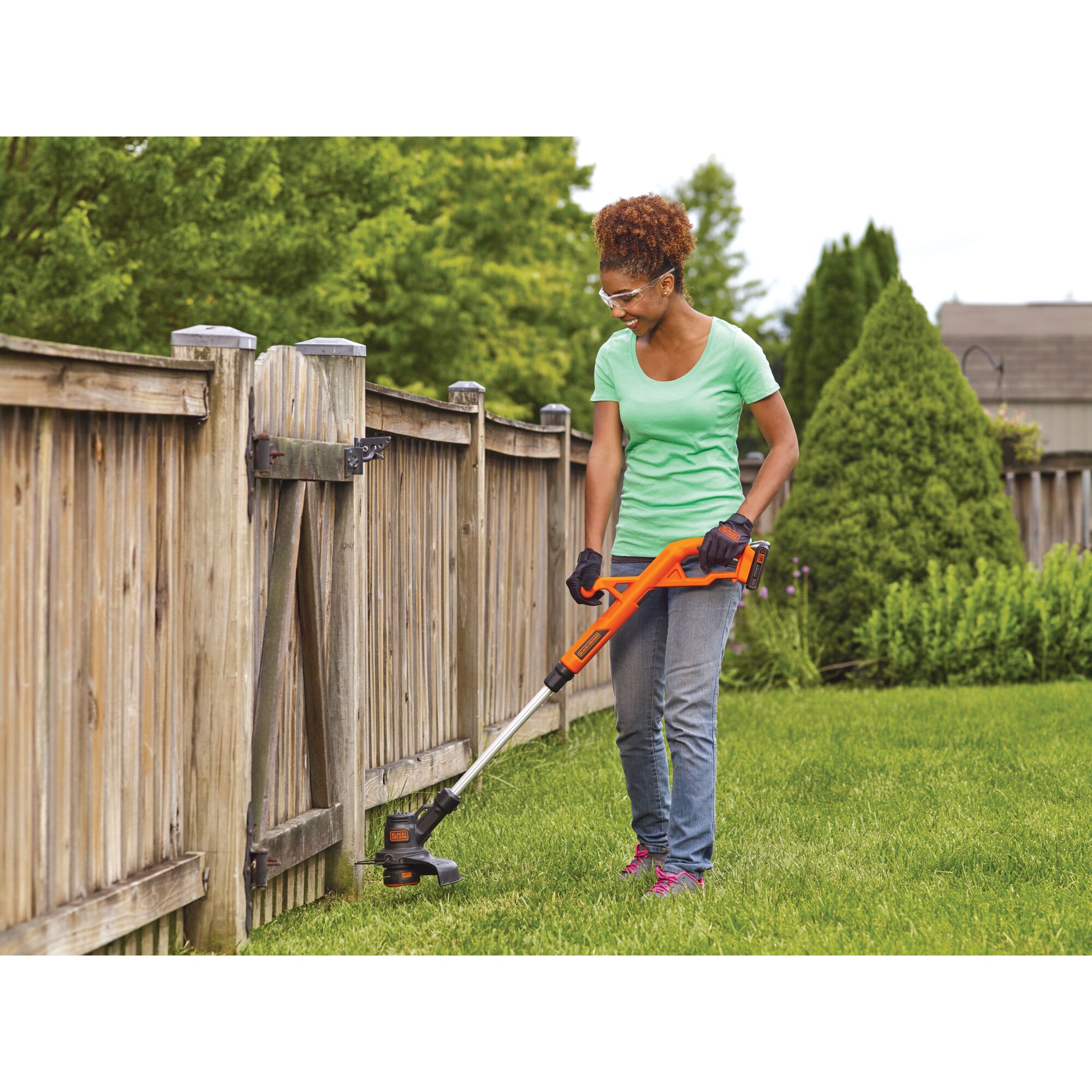Woman using 20V Max Lithium 10 In. String Trimmer / Edger near a fence.