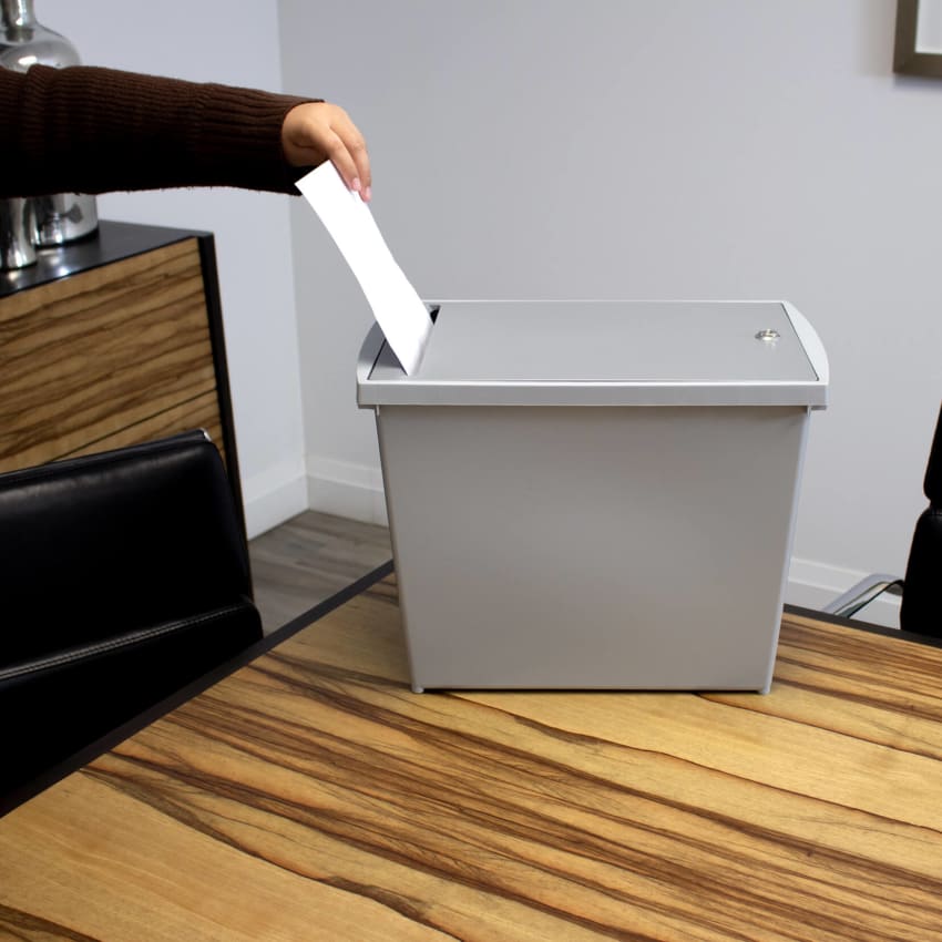 grey plastic box with locking lid for depositing important documents prior to shredding on a boardroom table