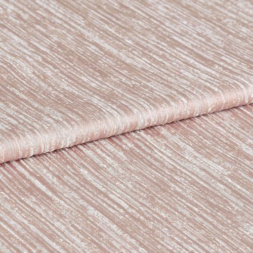 Shimmering, ribbed blush-pink fabric folded once, displaying horizontal crinkled texture and metallic sheen; close-up studio view with soft, even lighting emphasizing the tactile surface.