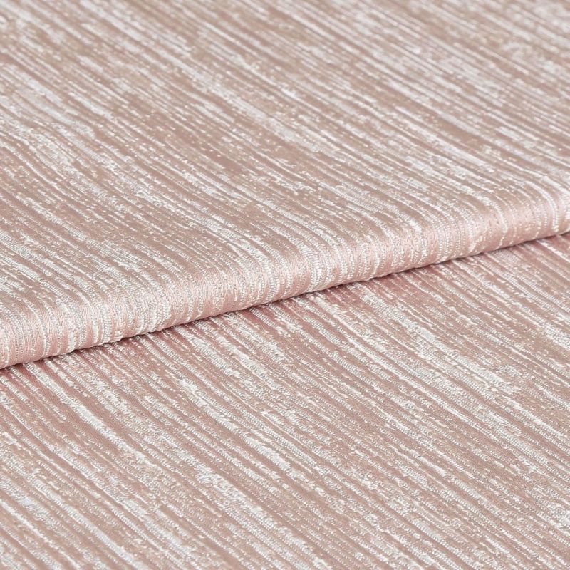 Shimmering, ribbed blush-pink fabric folded once, displaying horizontal crinkled texture and metallic sheen; close-up studio view with soft, even lighting emphasizing the tactile surface.