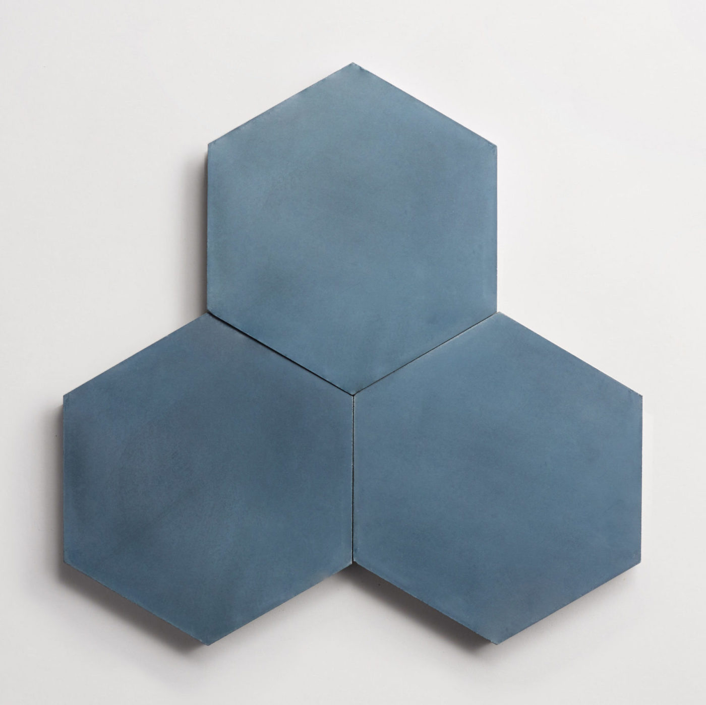 three blue hexagon tiles on a white surface.