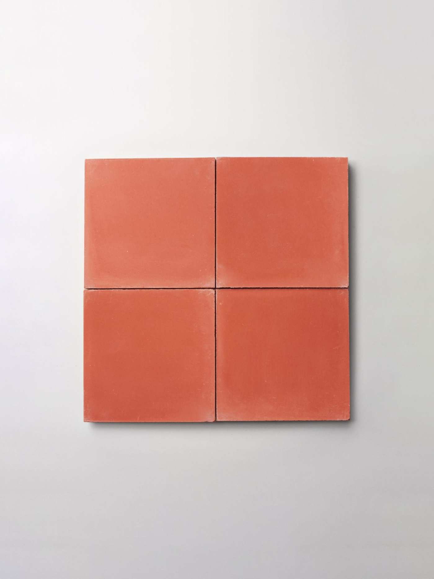 a set of four red tiles on a white surface.