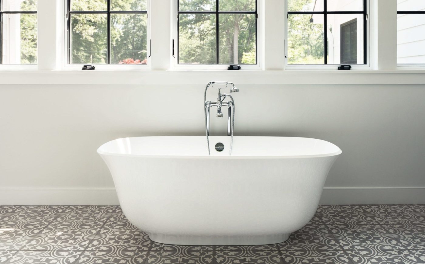 a white bathtub sits in front of a window in a bathroom.