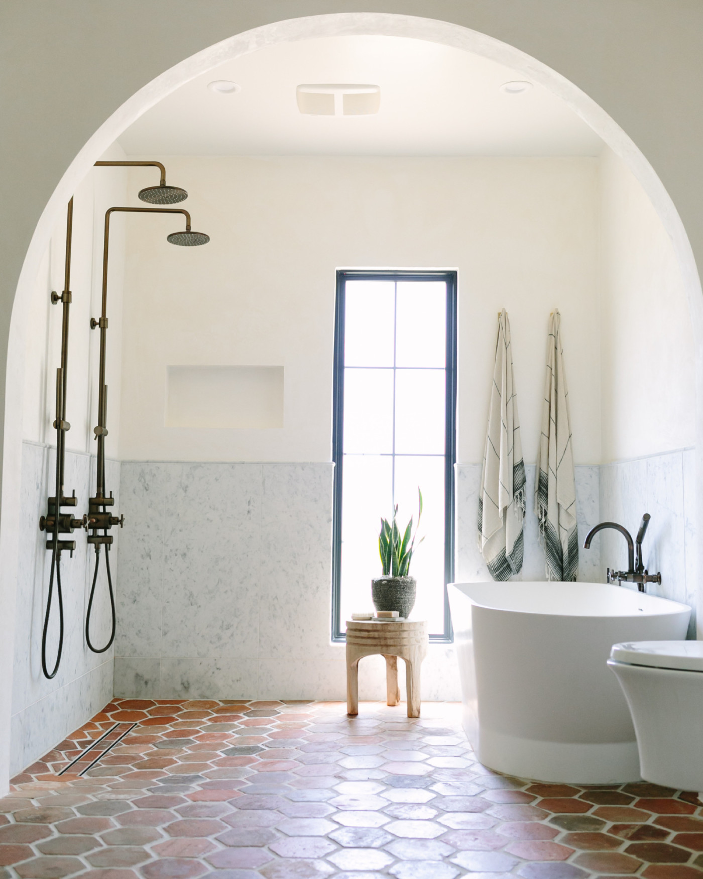 a bathroom with an arched doorway and tiled floor.