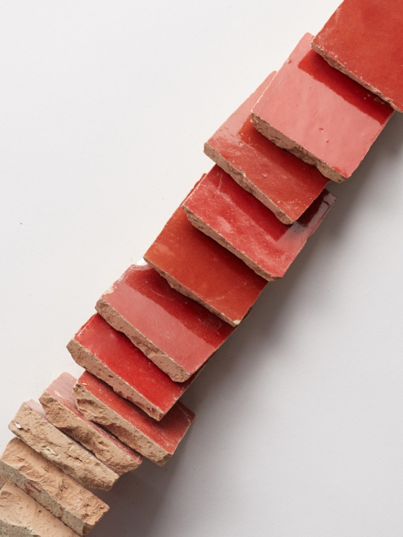 a stack of red tiles on a white surface.