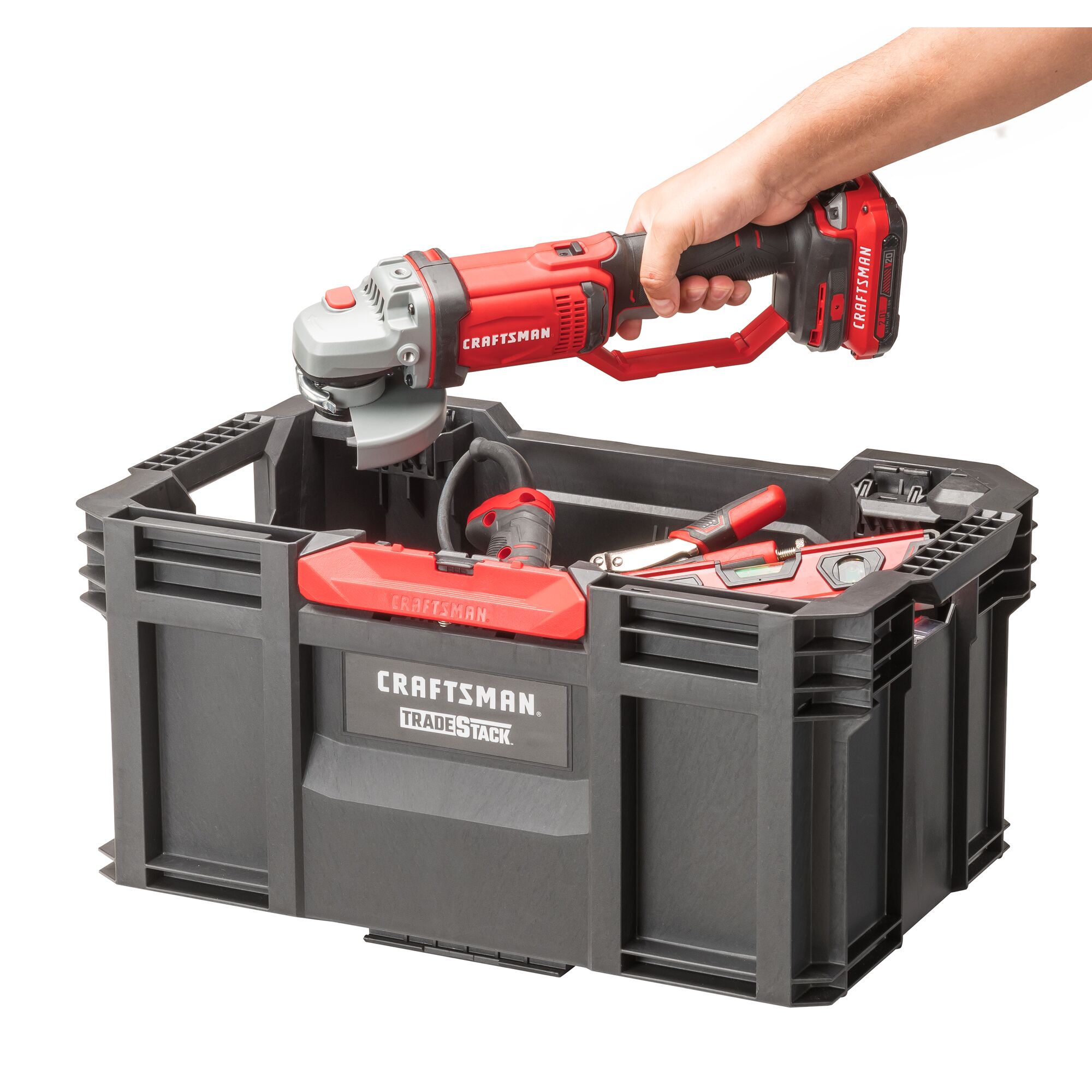 Hand placing CRAFTSMAN Angle Grinder into a CRAFTSMAN TRADESTACK Tool Crate, to join other assorted CRAFTSMAN hand tools and power tools